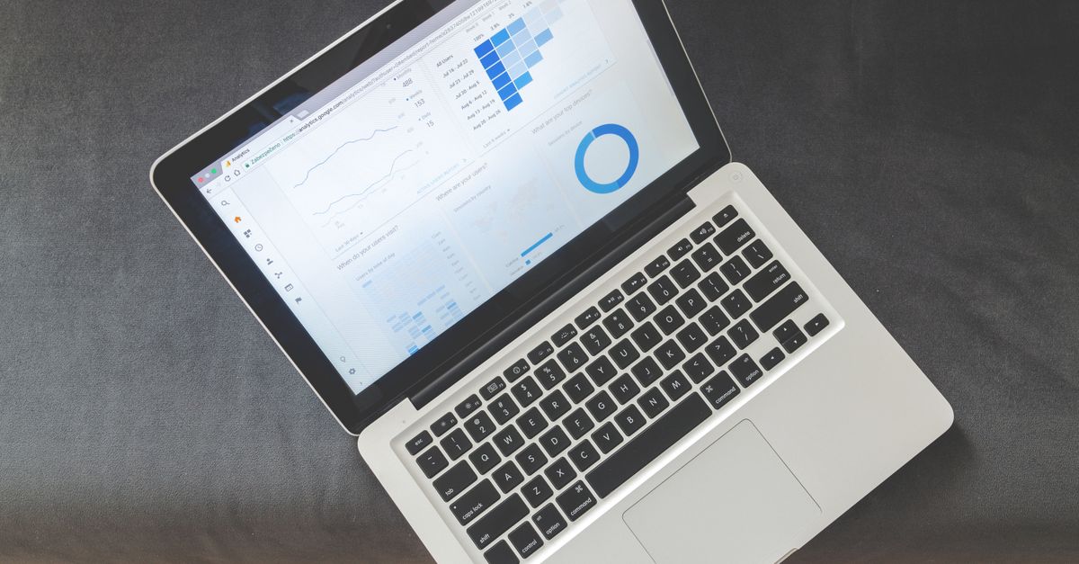 Portátil con visualizaciones de datos y gráficos analíticos sobre una mesa, representando métricas de marketing